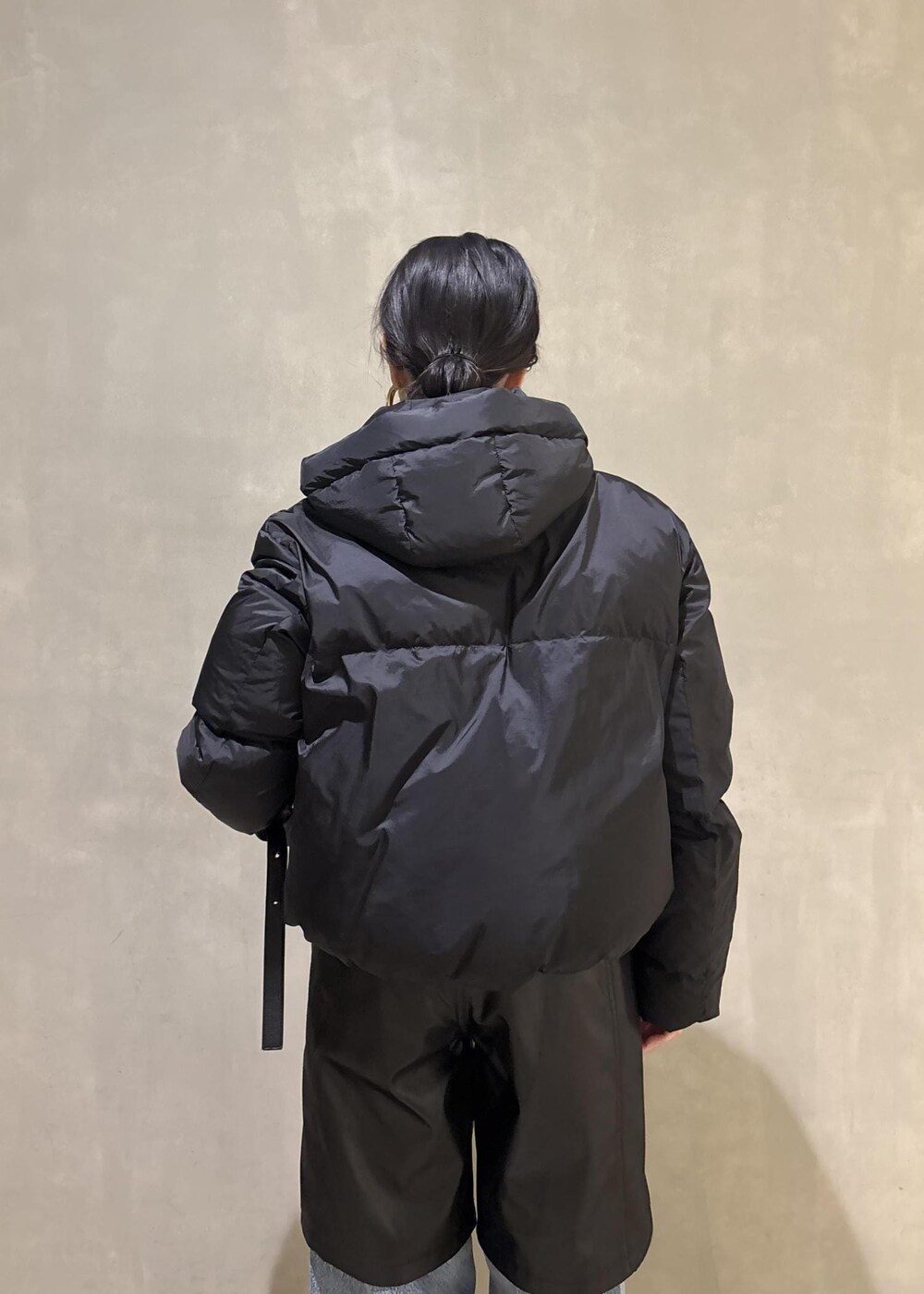 ブラック系のサンダル、ブラック系のダウンジャケット/コート、ブルー系のデニムパンツを着用したレディースの冬コーディネートの9枚目の写真