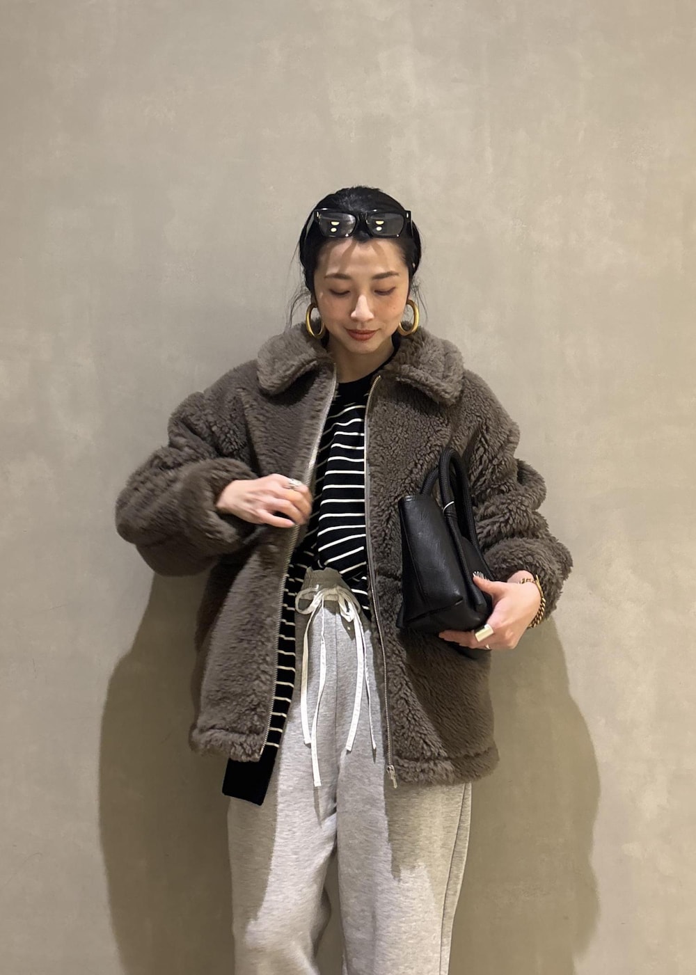 グリーン系のブルゾン、グレー系のその他パンツを着用したレディースの冬コーディネートの9枚目の写真