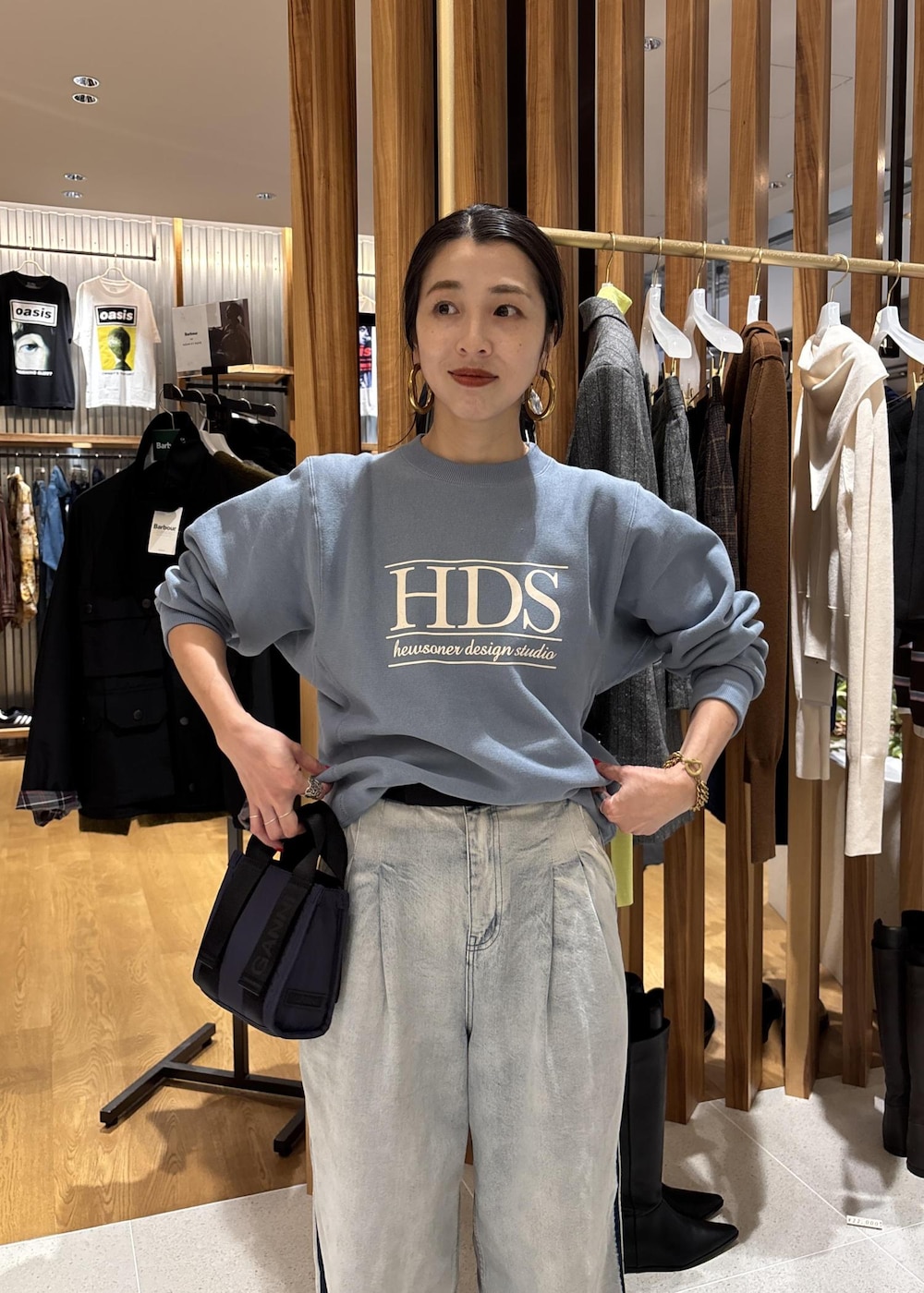 ブルー系のデニムパンツ、ブルー系のショルダーバッグ、ブルー系のスウェットを着用したレディースの秋コーディネートの9枚目の写真