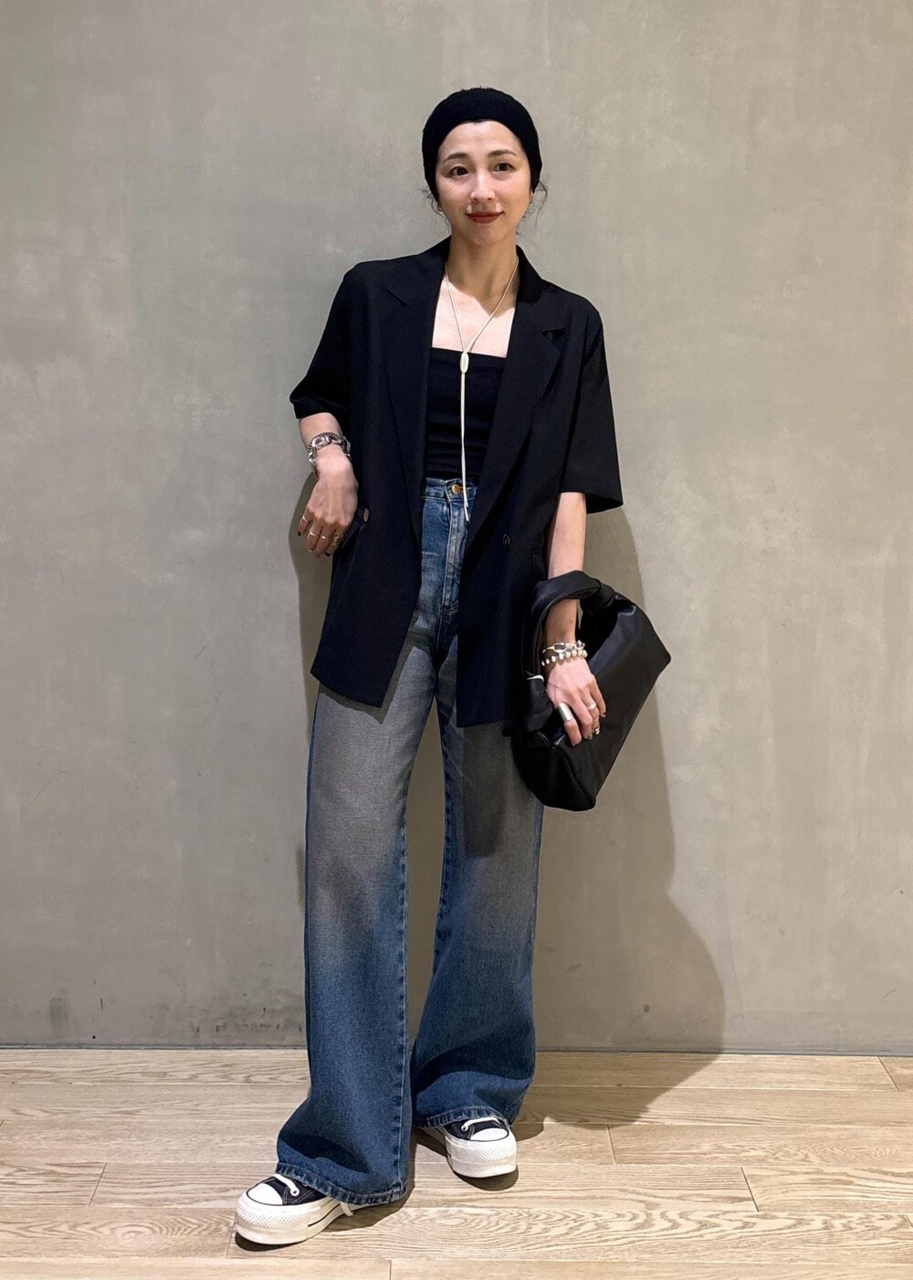 ブラック系のシャツ/ブラウス、ブルー系のデニムパンツ、シルバー系のネックレスを着用したレディースの夏コーディネートの2枚目の写真