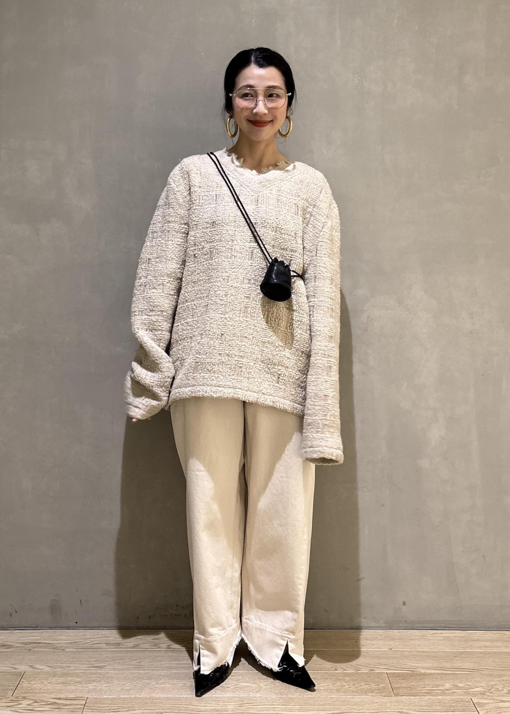 ブラック系のサンダル、ホワイト系のデニムパンツ、ブラック系のショルダーバッグを着用したレディースの冬コーディネートの8枚目の写真