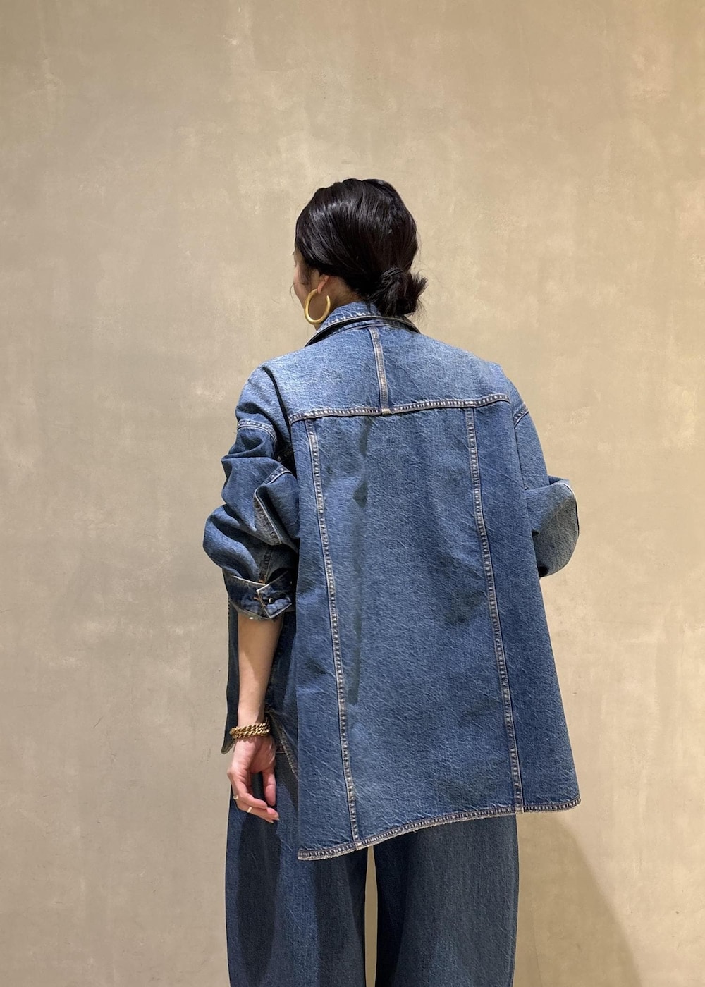 ブルー系のデニムジャケット、ブルー系のデニムパンツ、ブラック系のトートバッグを着用したレディースの春コーディネートの10枚目の写真