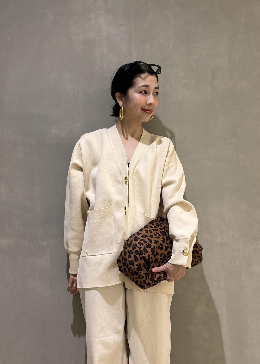 ブラック系のサンダル、ホワイト系のデニムパンツ、ホワイト系のカーディガン/ボレロを着用したレディースの冬コーディネートの8枚目の写真