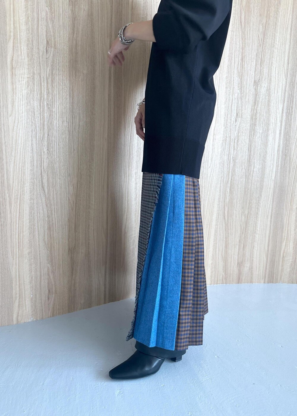 グレー系のスカート、ブラック系のブーツ、ブラック系のニット/セーターを着用したレディースの秋コーディネートの10枚目の写真