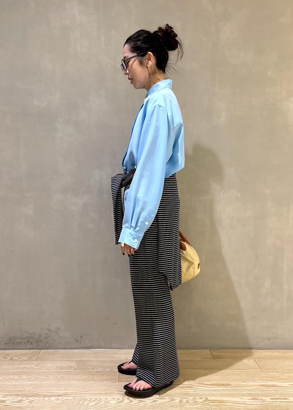 ブルー系のシャツ/ブラウス、ブラック系のサンダルを着用したレディースの夏コーディネートの2枚目の写真