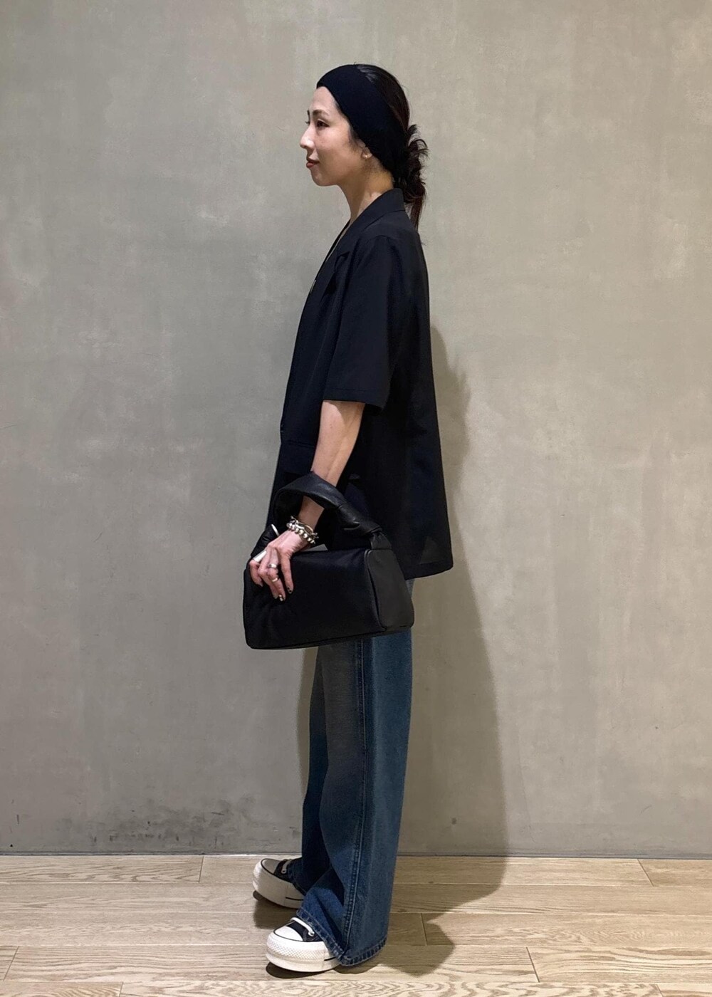 ブラック系のシャツ/ブラウス、ブルー系のデニムパンツ、シルバー系のネックレスを着用したレディースの夏コーディネートの6枚目の写真