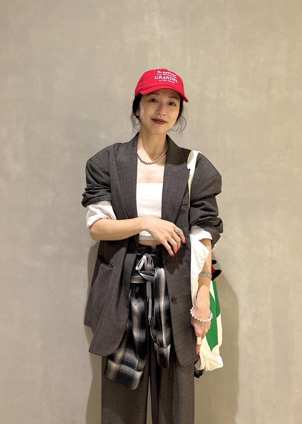 ブラック系のシャツ/ブラウス、グリーン系のトートバッグ、ブラック系のキャップを着用したレディースの秋コーディネートの9枚目の写真