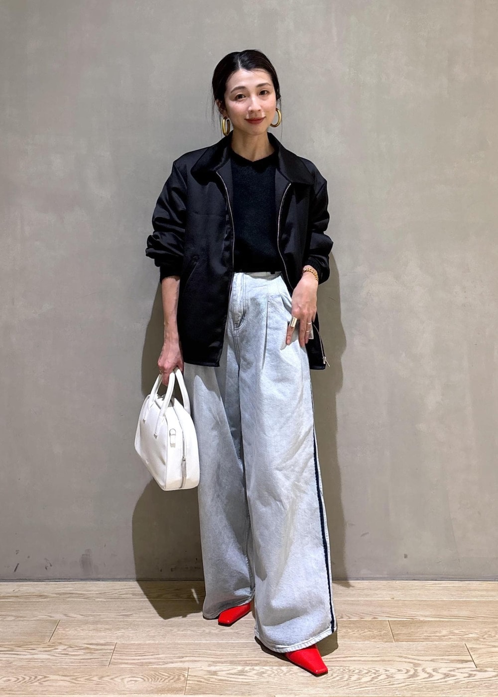 ブラック系のニット/セーター、ホワイト系のボストンバッグ、ブルー系のその他パンツを着用したレディースの冬コーディネートの2枚目の写真