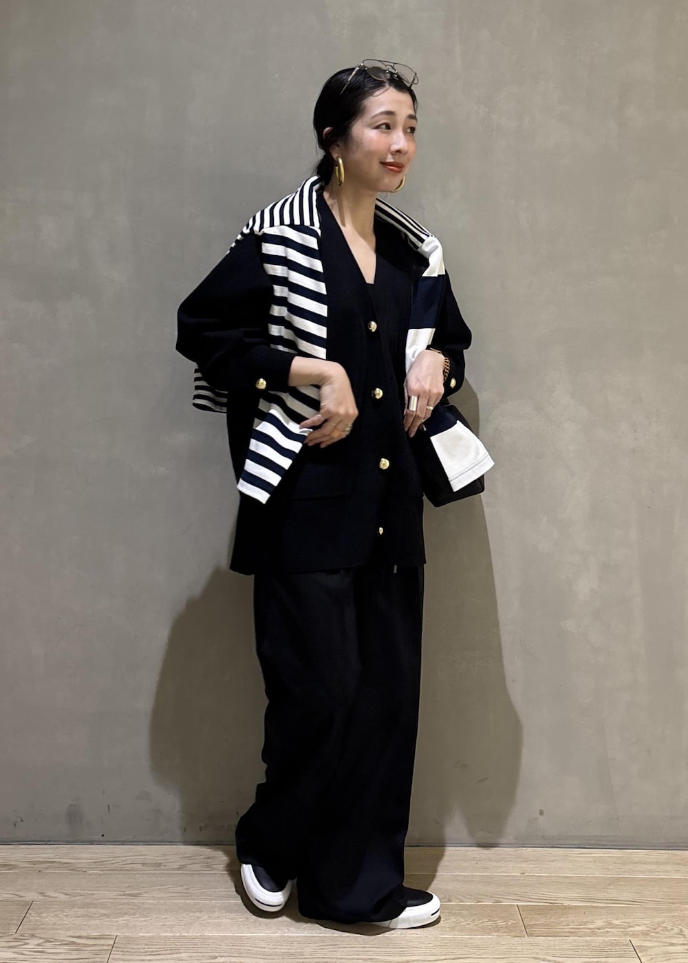 ブルー系のTシャツ/カットソー、ブラック系のカーディガン/ボレロ、ブラック系のスラックスを着用したレディースの冬コーディネートの7枚目の写真