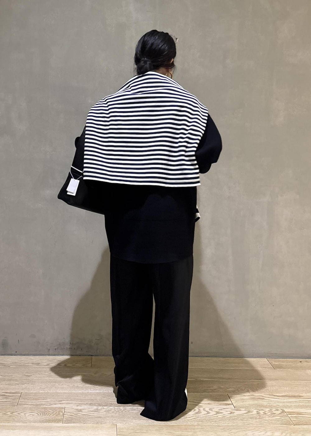 ブルー系のTシャツ/カットソー、ブラック系のカーディガン/ボレロ、ブラック系のスラックスを着用したレディースの冬コーディネートの9枚目の写真