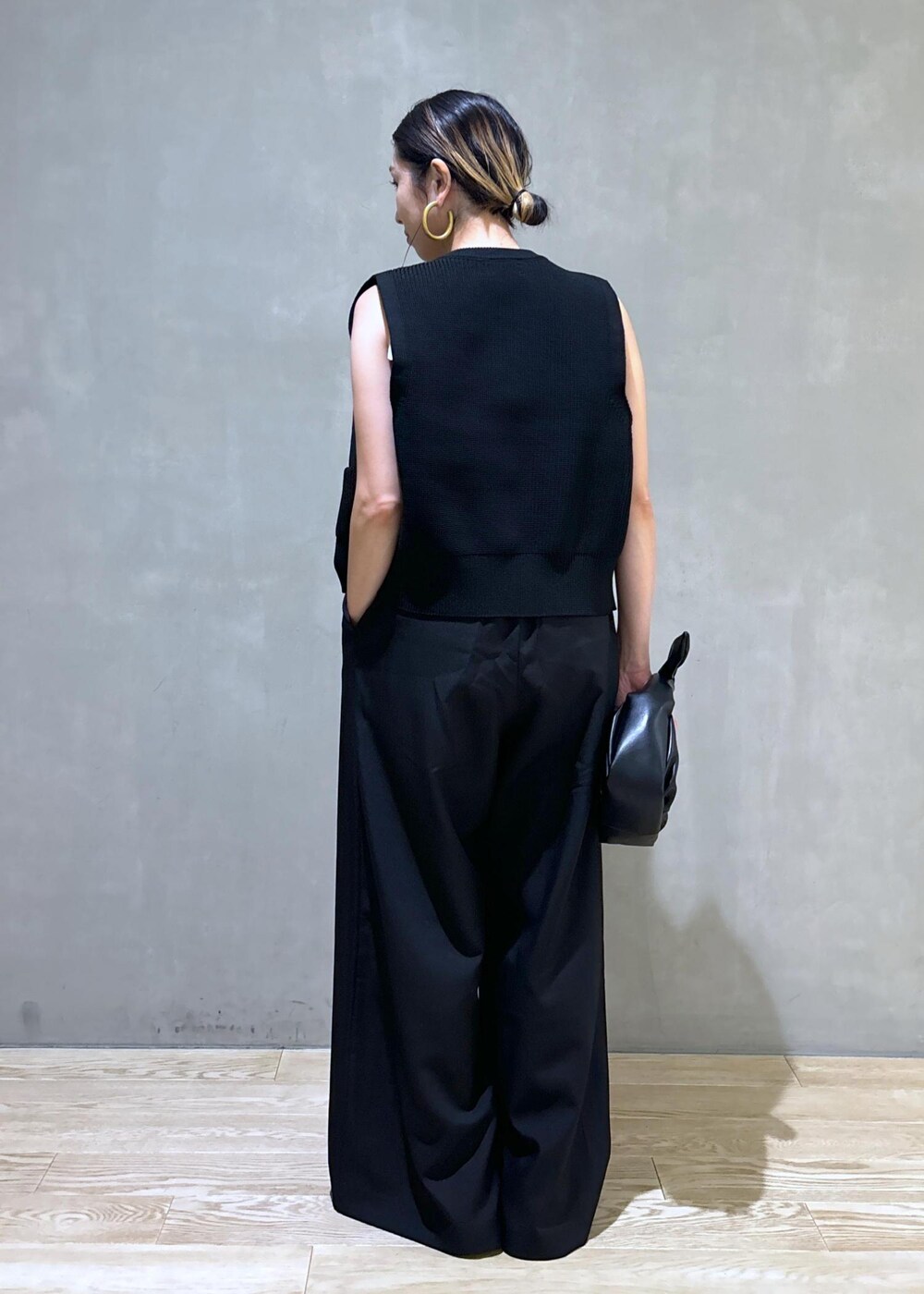 シルバー系のスニーカー、ブラック系のニット/セーター、ブラック系のショルダーバッグを着用したレディースの夏コーディネートの6枚目の写真