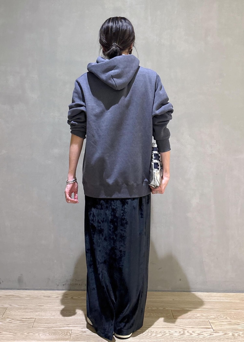 グレー系のスニーカー、ブラック系のスカート、グレー系のパーカーを着用したレディースの冬コーディネートの4枚目の写真