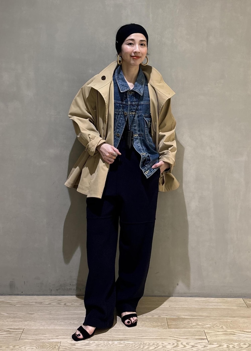 ベージュ系のトレンチコート、ブルー系のデニムジャケット、ブルー系のその他パンツを着用したレディースの春コーディネートの3枚目の写真