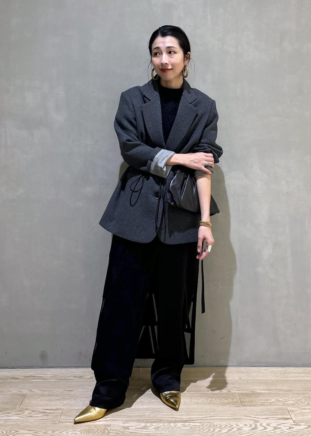 グレー系のニット/セーター、グレー系のテーラードジャケット、ブラック系のその他パンツを着用したレディースの秋コーディネートの2枚目の写真