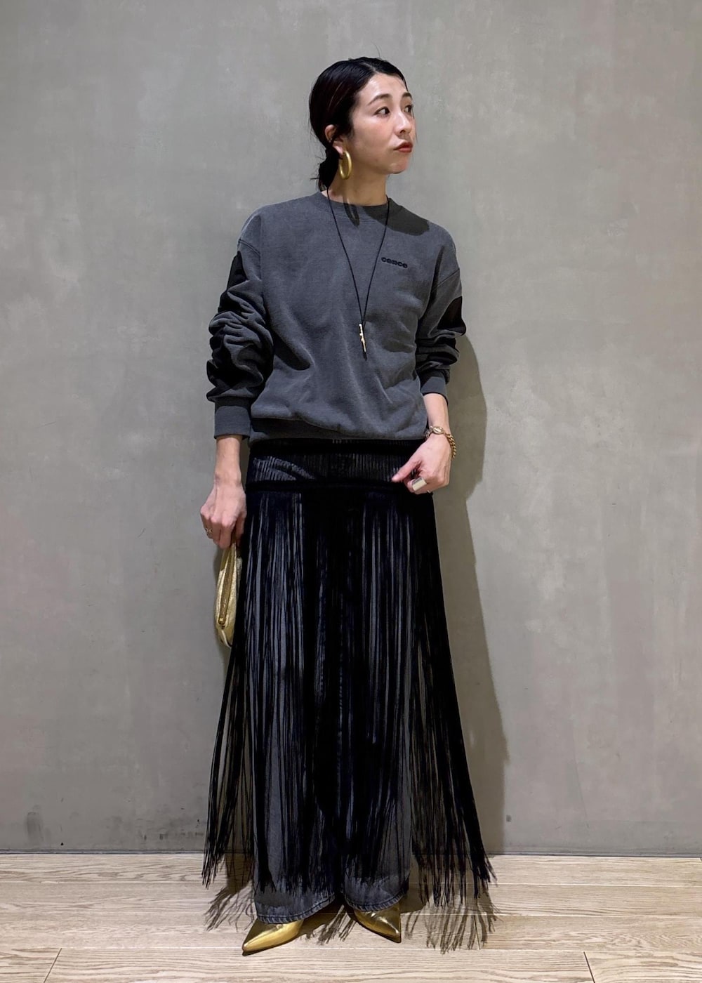 ブラック系のデニムパンツ、ブラック系のスカート、ベージュ系のポーチを着用したレディースの冬コーディネートの7枚目の写真