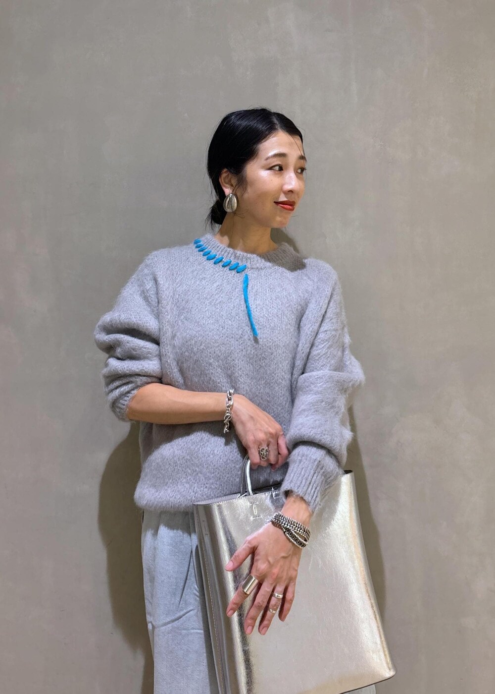 ホワイト系のパンプス、シルバー系のトートバッグ、ブルー系のその他パンツを着用したレディースの秋コーディネートの7枚目の写真
