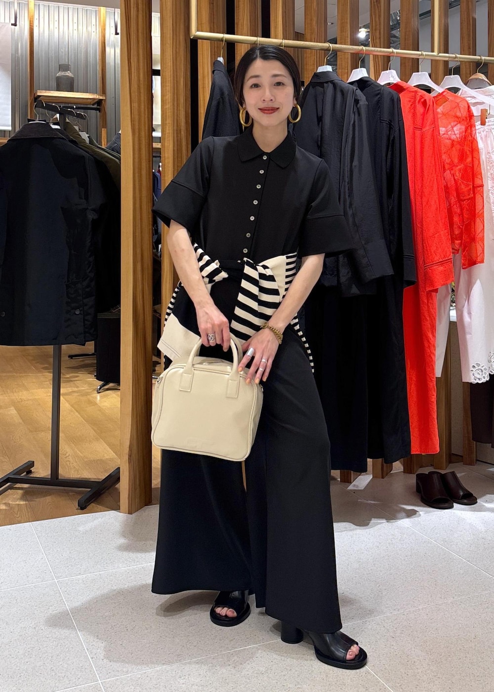 ブラック系のTシャツ/カットソー、ブラック系のつなぎ/オールインワン、ブラック系のサンダルを着用したレディースの春コーディネートの2枚目の写真