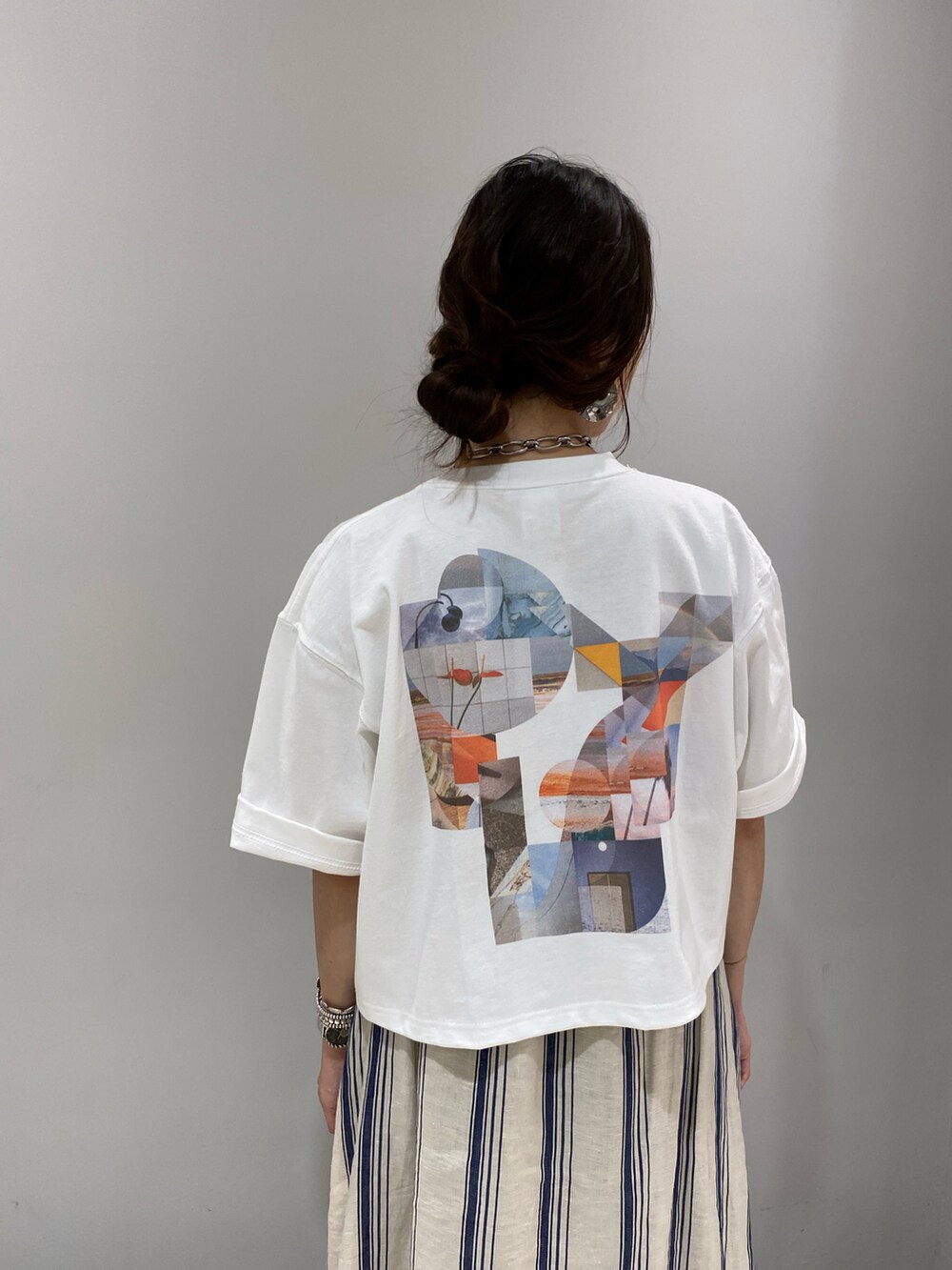 ベージュ系のワンピース、ホワイト系のTシャツ/カットソー、シルバー系のネックレスを着用したレディースの春コーディネートの2枚目の写真