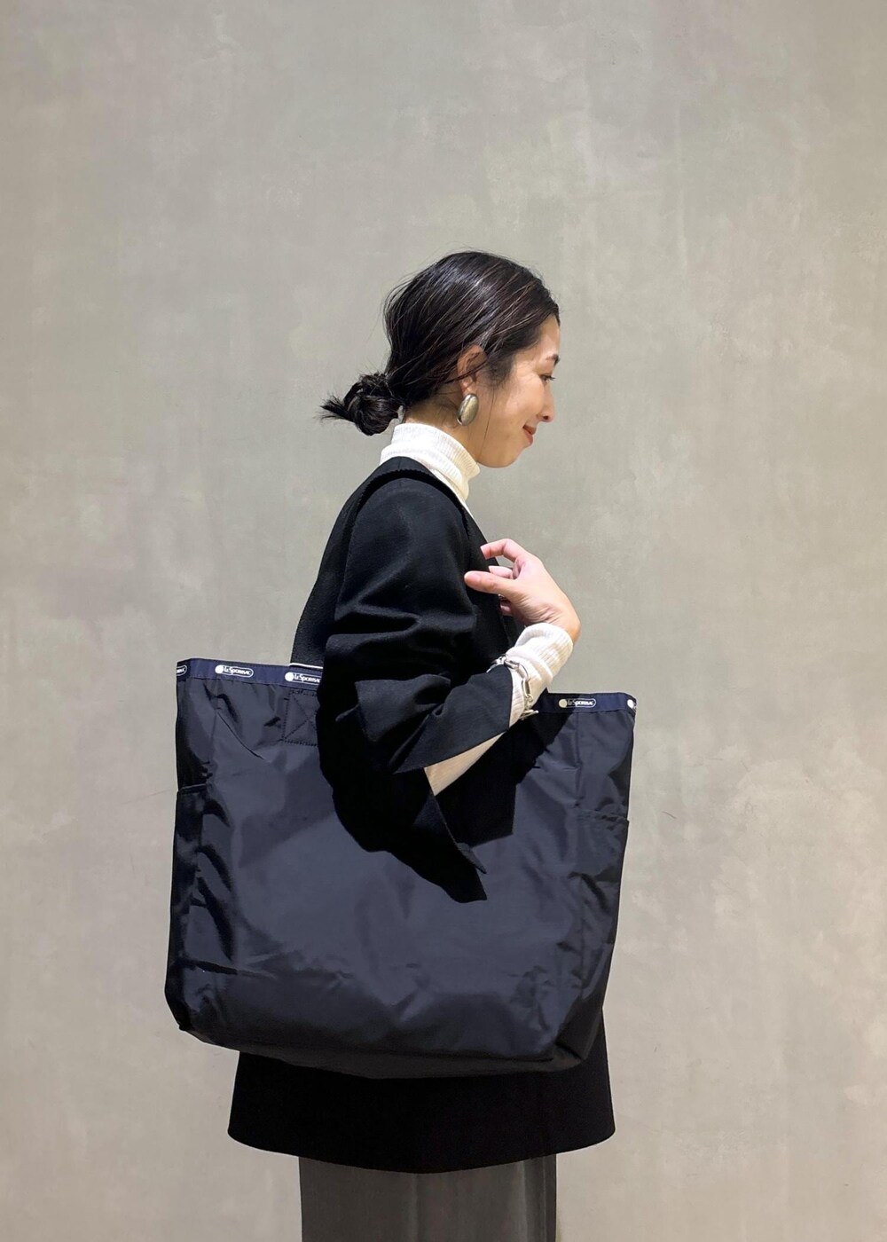 グレー系のスニーカー、ホワイト系のニット/セーター、ブラック系のシャツ/ブラウスを着用したレディースの秋コーディネートの8枚目の写真