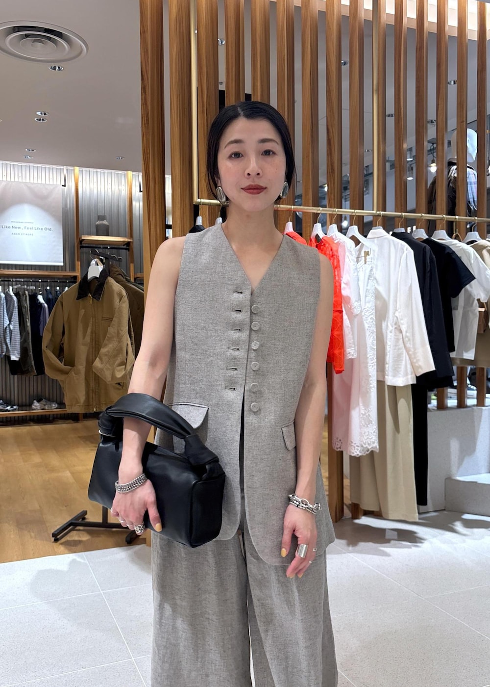 ブラック系のハンドバッグ、ベージュ系のその他パンツ、ベージュ系のベストを着用したレディースの春コーディネートの10枚目の写真