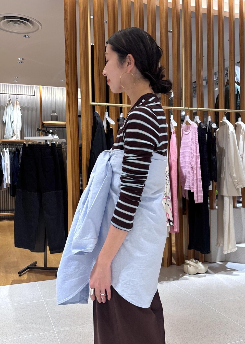 ブラック系のハンドバッグ、ブルー系のシャツ/ブラウス、ブラウン系のTシャツ/カットソーを着用したレディースの春コーディネートの9枚目の写真