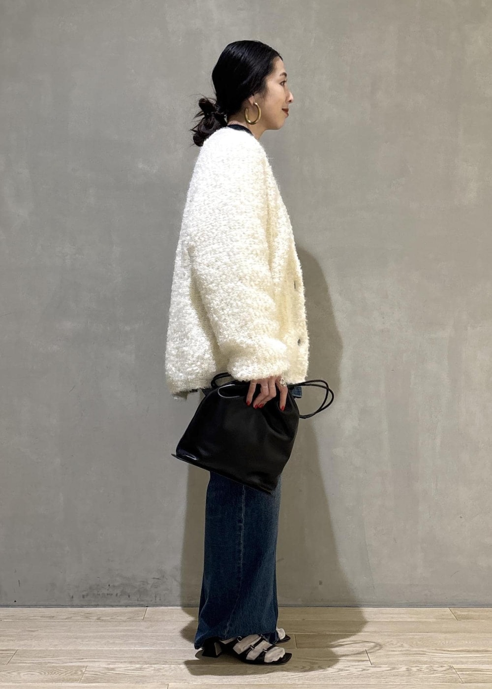 ブラック系のショルダーバッグ、ブルー系のデニムパンツ、ブルー系のカバーオールを着用したレディースの秋コーディネートの6枚目の写真