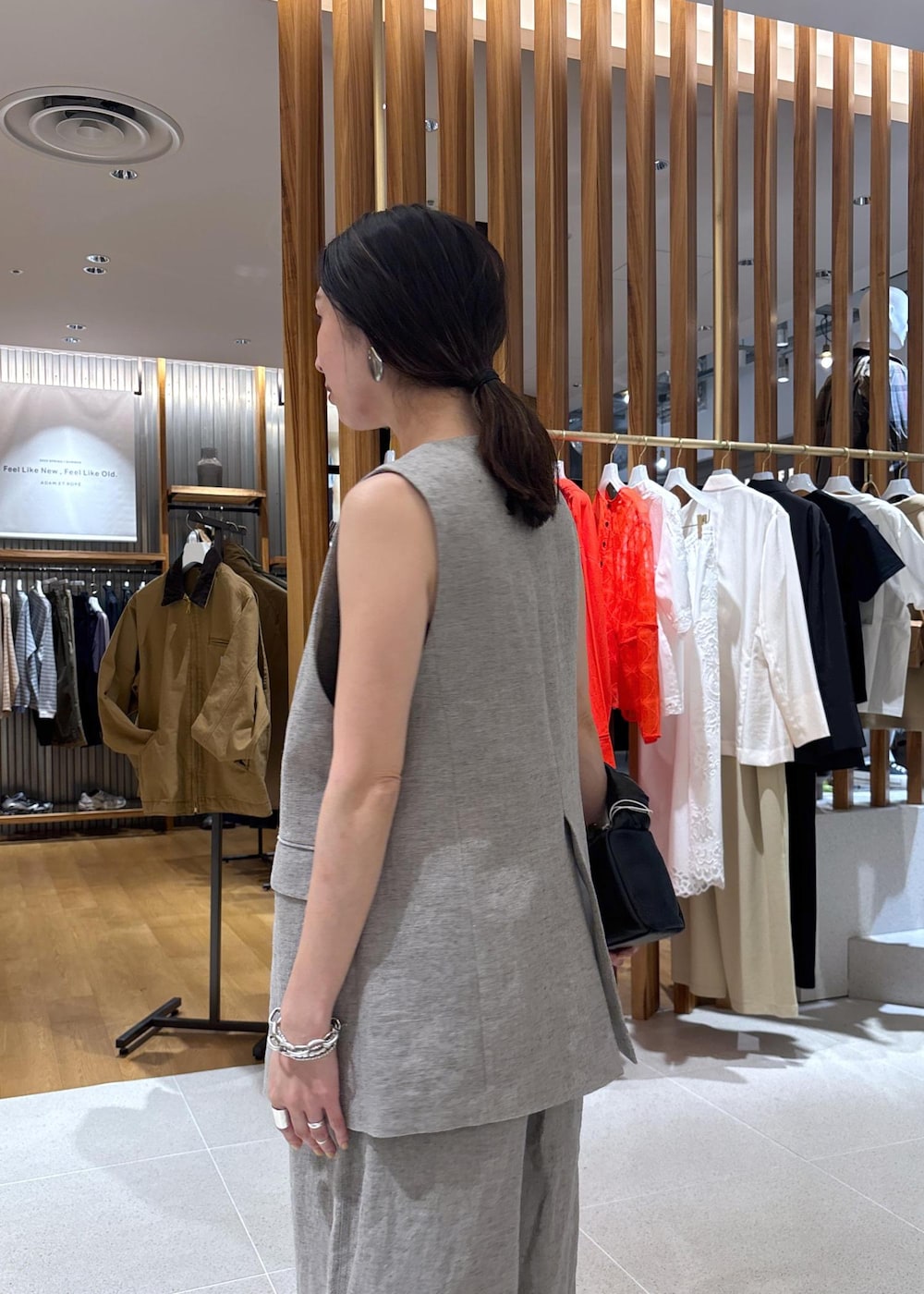 ブラック系のハンドバッグ、ベージュ系のその他パンツ、ベージュ系のベストを着用したレディースの春コーディネートの7枚目の写真