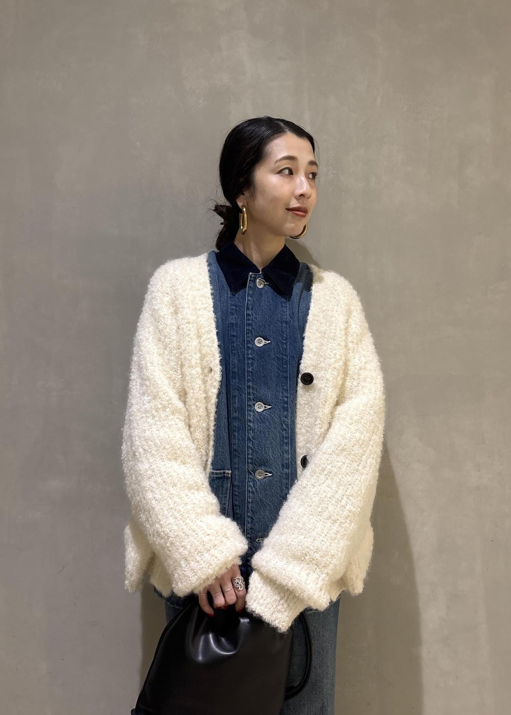 ブラック系のショルダーバッグ、ブルー系のデニムパンツ、ブルー系のカバーオールを着用したレディースの秋コーディネートの10枚目の写真