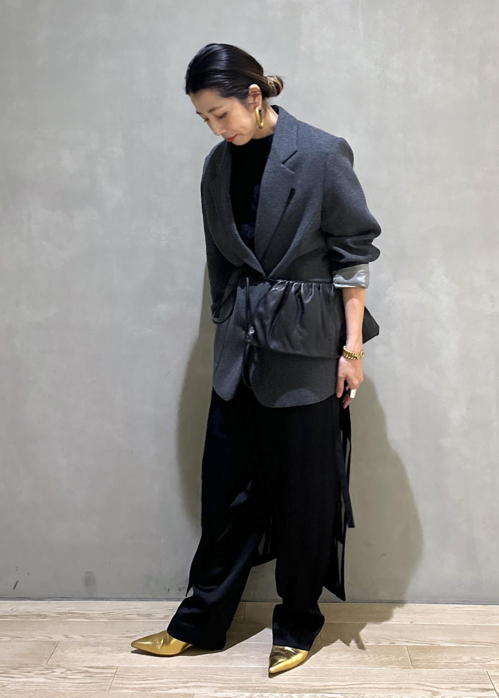 グレー系のニット/セーター、グレー系のテーラードジャケット、ブラック系のその他パンツを着用したレディースの秋コーディネートの5枚目の写真