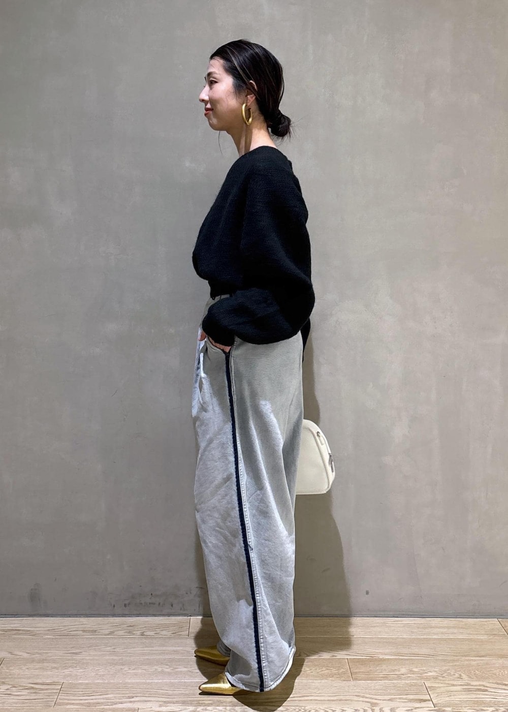 ブラック系のニット/セーター、ホワイト系のボストンバッグ、ブルー系のその他パンツを着用したレディースの冬コーディネートの7枚目の写真