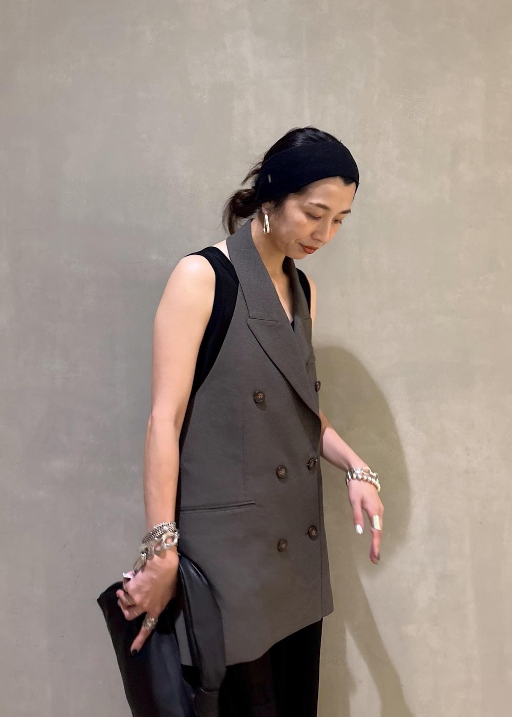 ブラック系のハンドバッグ、ブラック系のワンピースを着用したレディースの夏コーディネートの7枚目の写真