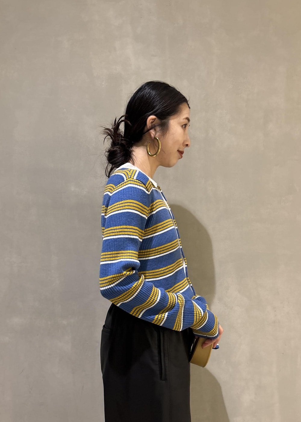 ブルー系のポロシャツ、ブラック系のその他パンツ、イエロー系のキーホルダーを着用したレディースの秋コーディネートの8枚目の写真