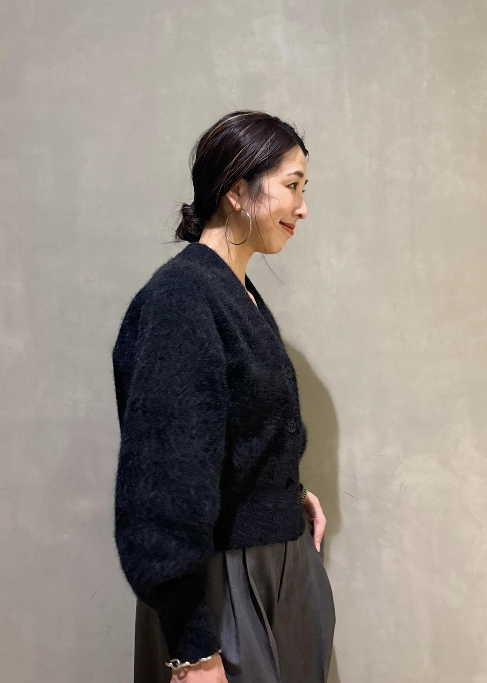 ホワイト系のボストンバッグ、グレー系のカーディガン/ボレロ、ブルー系のスニーカーを着用したレディースの秋コーディネートの9枚目の写真