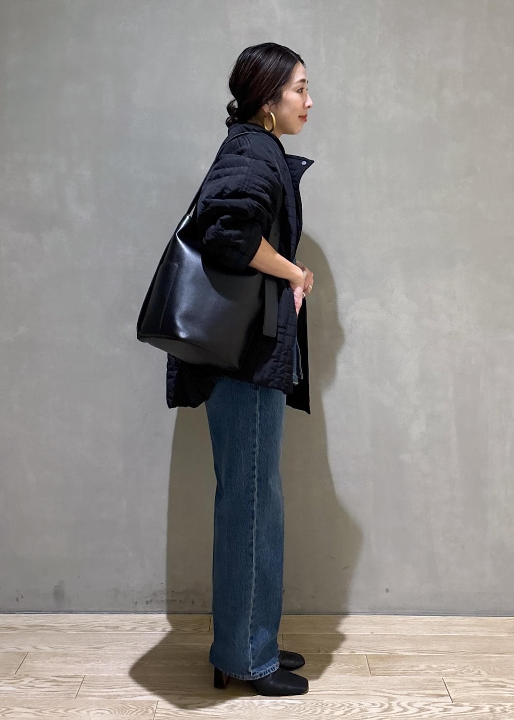 ブラック系のショルダーバッグ、ブルー系のシャツ/ブラウス、ブラック系のブルゾンを着用したレディースの冬コーディネートの2枚目の写真