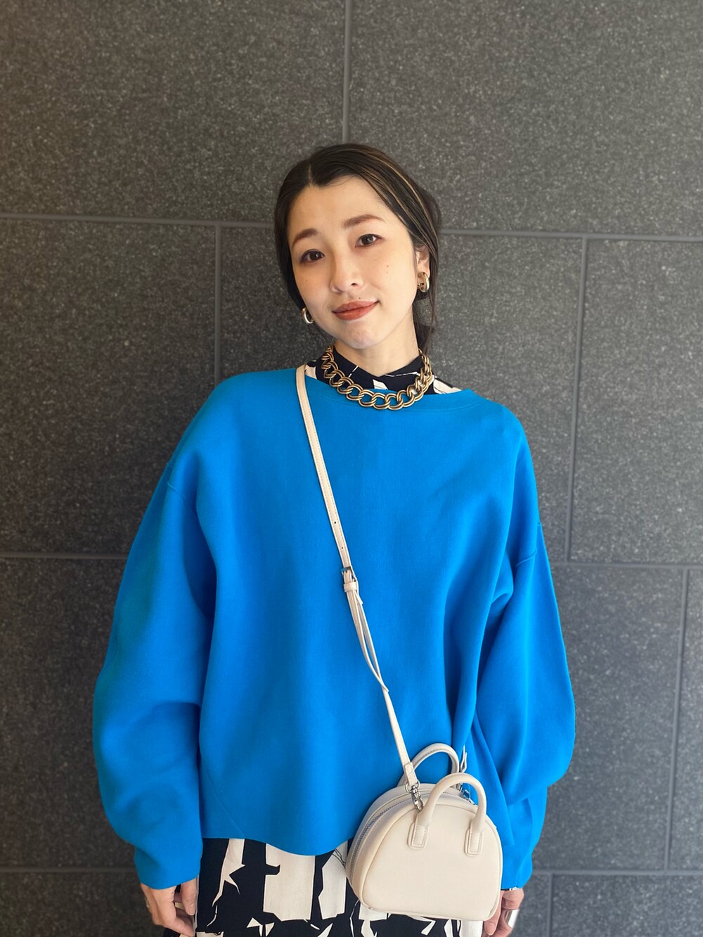 ブラック系のワンピース、ブラック系のブーツ、ホワイト系のショルダーバッグを着用したレディースの春コーディネートの2枚目の写真