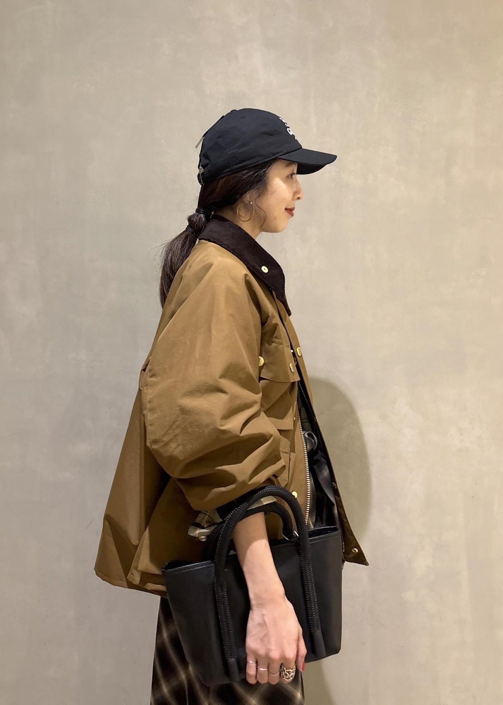 イエロー系のブルゾン、ブラック系のキャップを着用したレディースの秋コーディネートの8枚目の写真