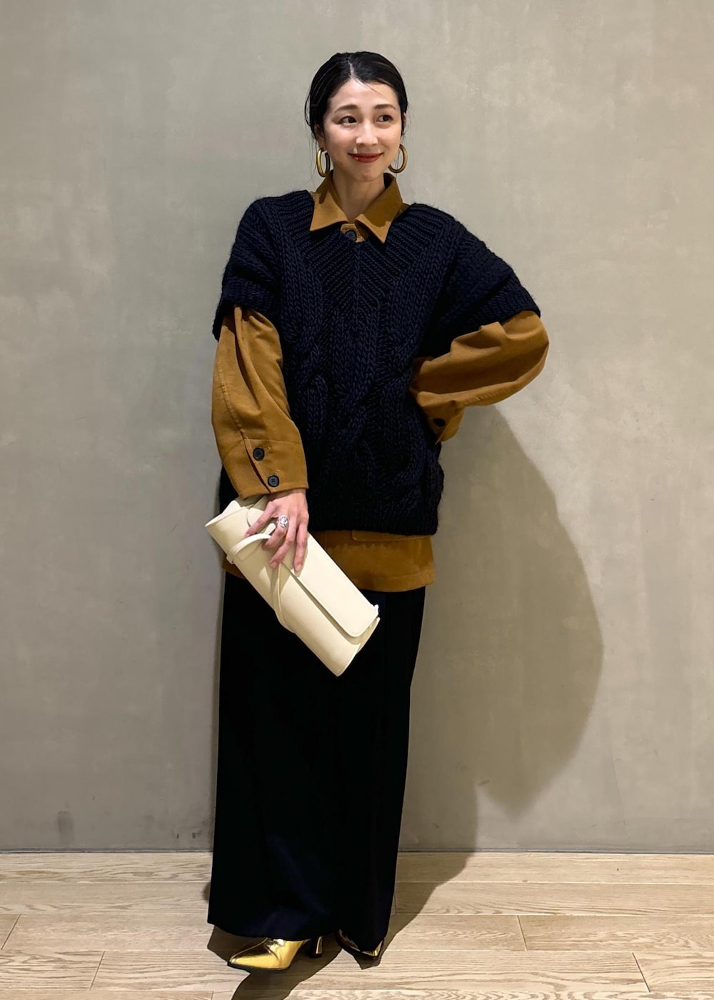 ブラック系のニット/セーター、ゴールド系のブーツ、イエロー系のブルゾンを着用したレディースの秋コーディネートの3枚目の写真