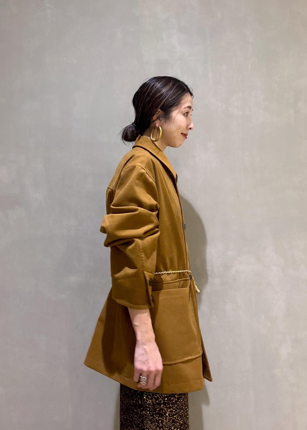 ブラック系のブーツ、ブラック系のスカート、イエロー系のブルゾンを着用したレディースの冬コーディネートの7枚目の写真