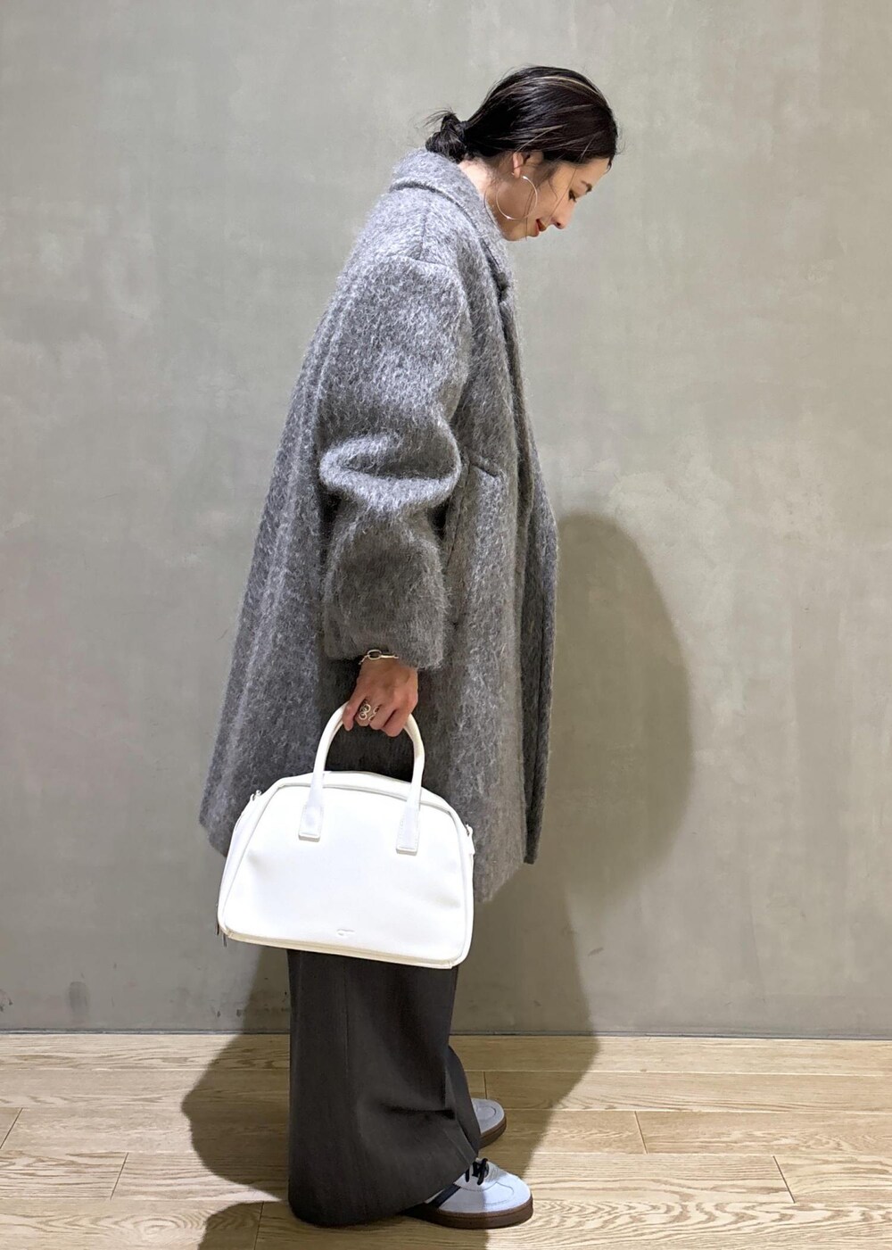 ホワイト系のボストンバッグ、グレー系のカーディガン/ボレロ、グレー系のチェスターコートを着用したレディースの秋コーディネートの6枚目の写真