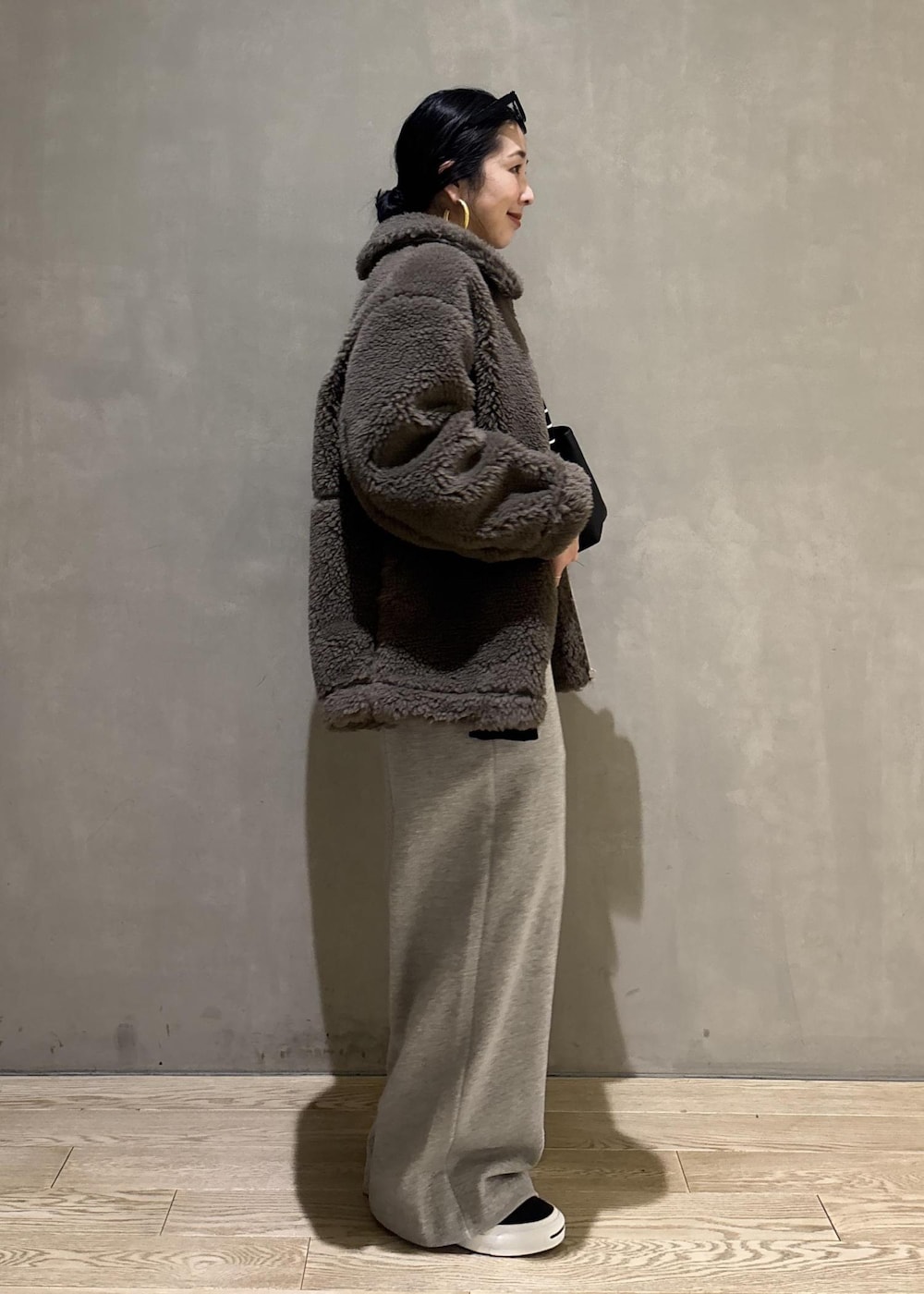 グリーン系のブルゾン、グレー系のその他パンツを着用したレディースの冬コーディネートの4枚目の写真