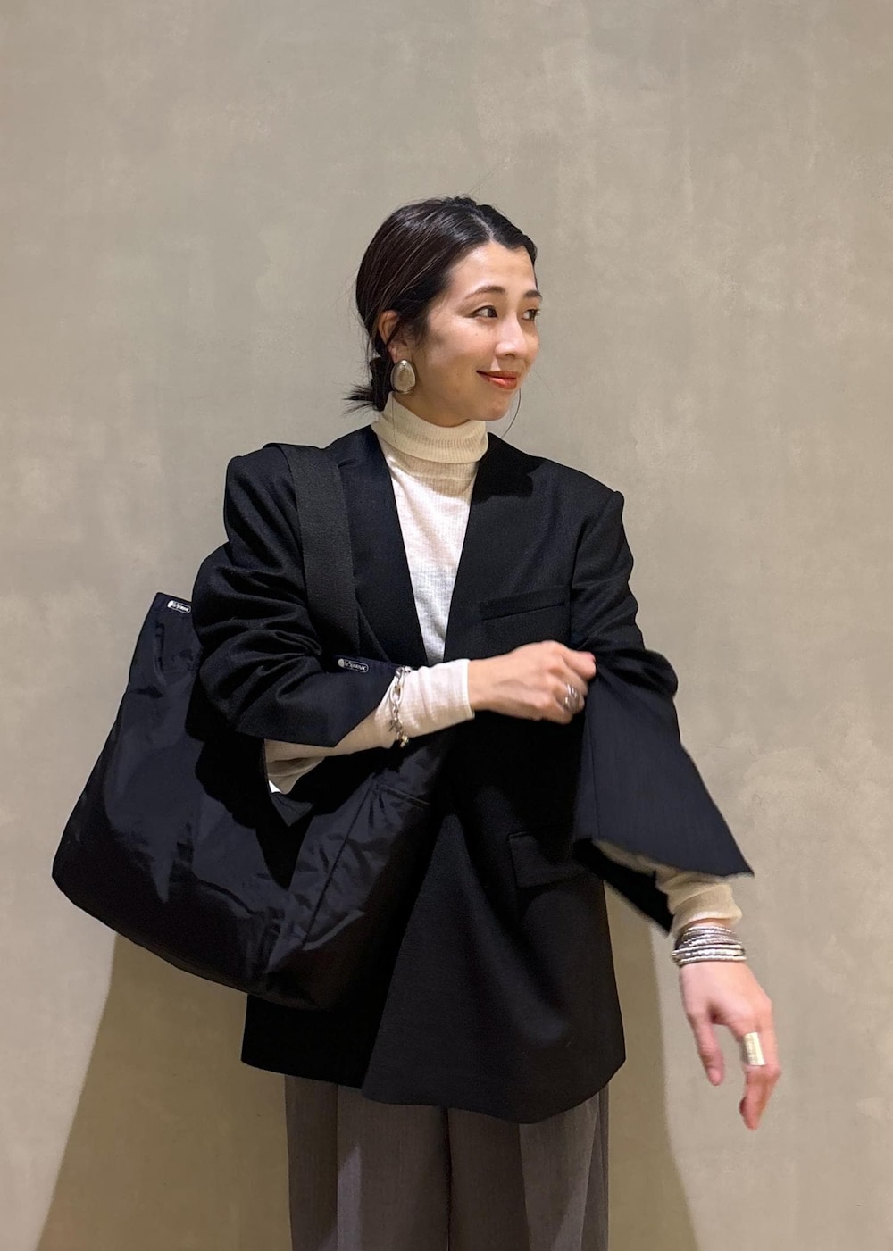 グレー系のスニーカー、ホワイト系のニット/セーター、ブラック系のシャツ/ブラウスを着用したレディースの秋コーディネートの7枚目の写真