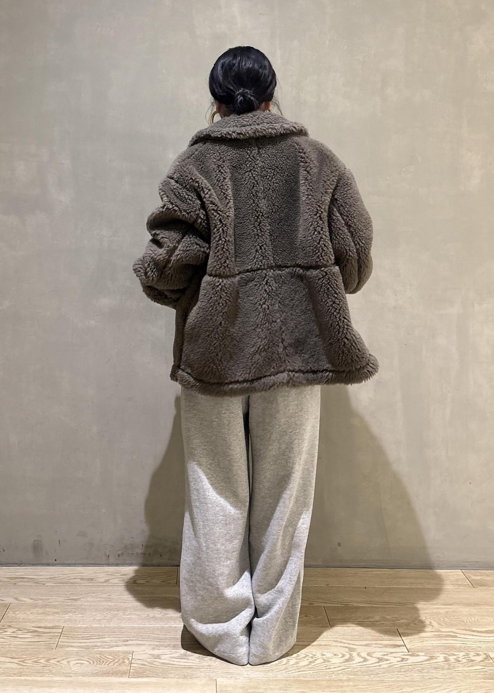 グリーン系のブルゾン、グレー系のその他パンツを着用したレディースの冬コーディネートの5枚目の写真