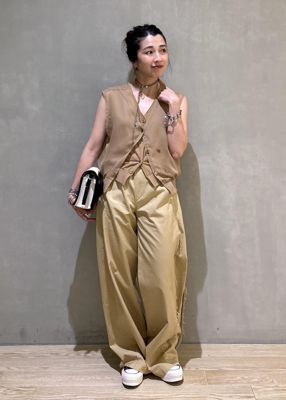 ベージュ系のTシャツ/カットソーを着用したレディースの夏コーディネートの2枚目の写真