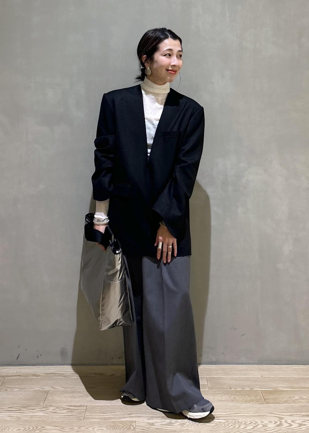 グレー系のスニーカー、ホワイト系のニット/セーター、ブラック系のシャツ/ブラウスを着用したレディースの秋コーディネートの3枚目の写真