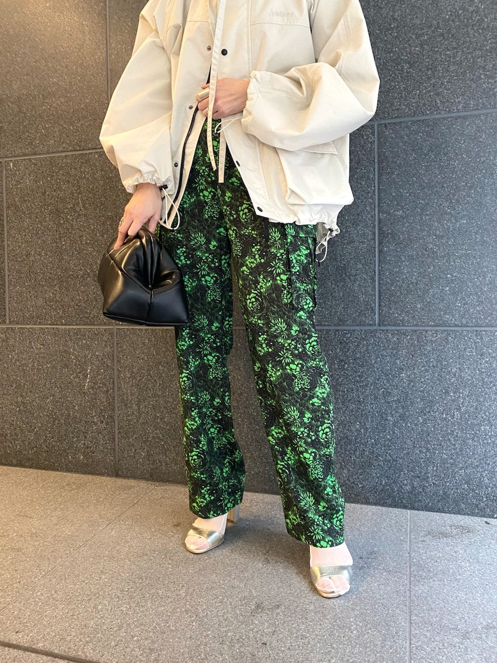 ブラック系のカーゴパンツ、ブラック系のクラッチバッグ、ホワイト系のブルゾンを着用したレディースの春コーディネートの4枚目の写真