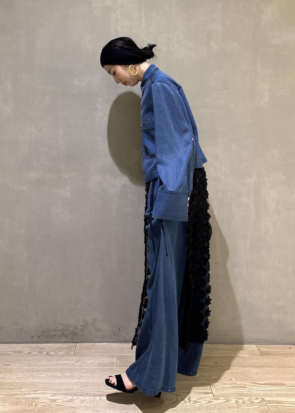 ブルー系のシャツ/ブラウス、ブルー系のデニムパンツ、ブラック系のクラッチバッグを着用したレディースの冬コーディネートの4枚目の写真