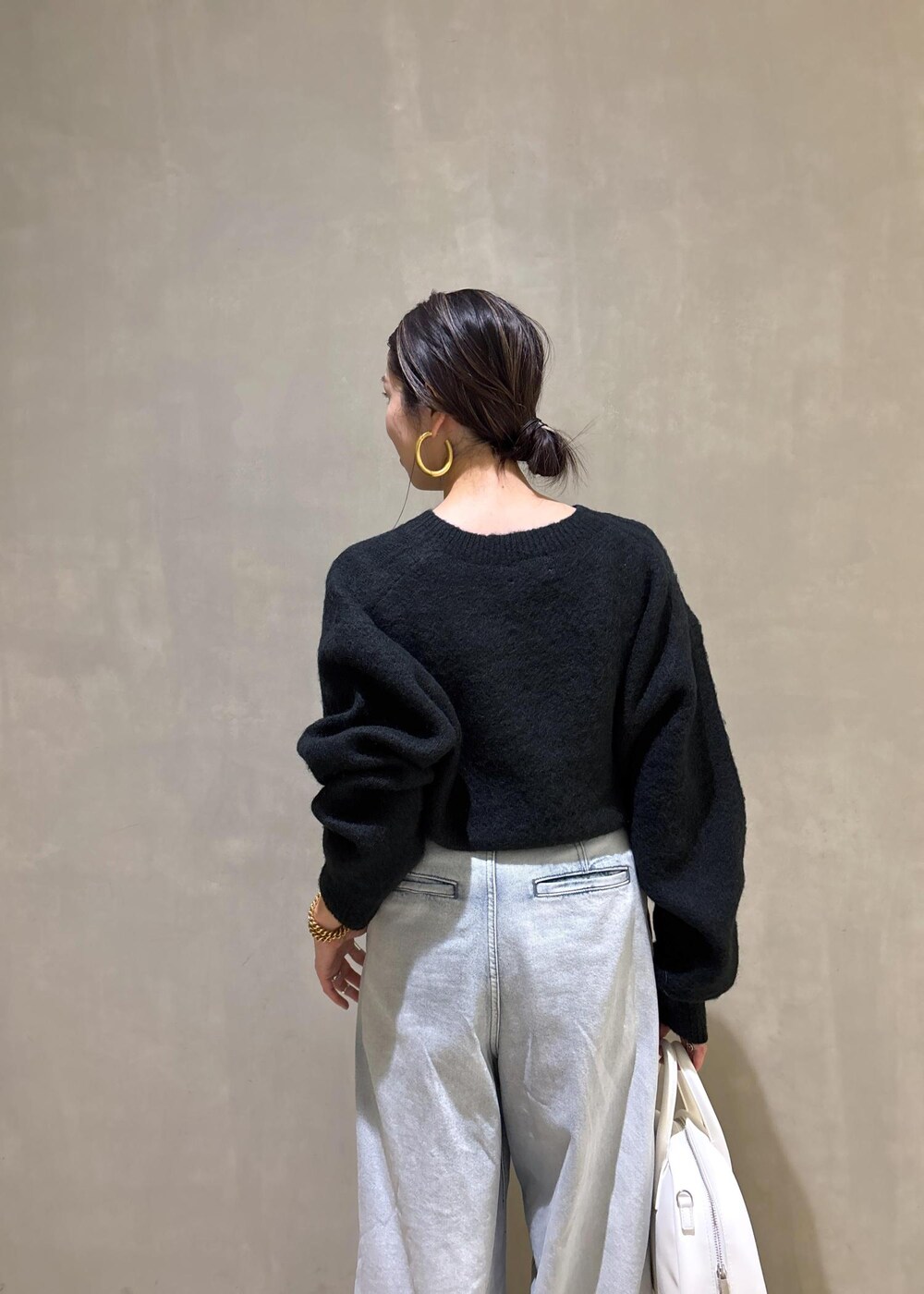 ブラック系のニット/セーター、ホワイト系のボストンバッグ、ブルー系のその他パンツを着用したレディースの冬コーディネートの10枚目の写真