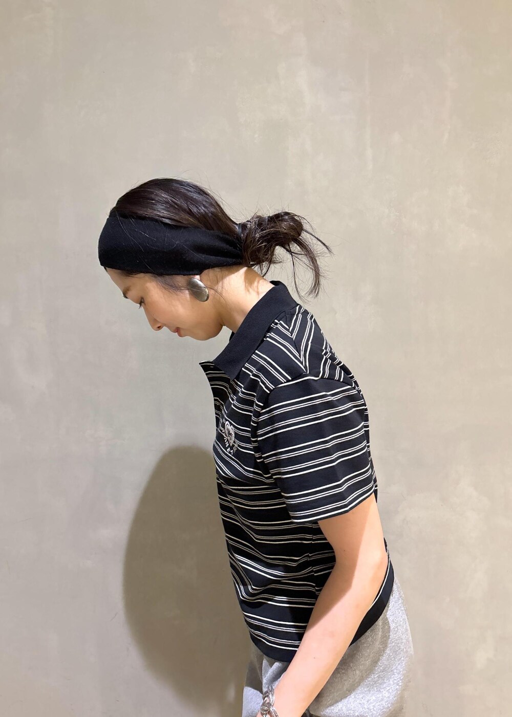 グレー系のスウェットパンツ、ブラック系のポロシャツを着用したレディースの夏コーディネートの9枚目の写真