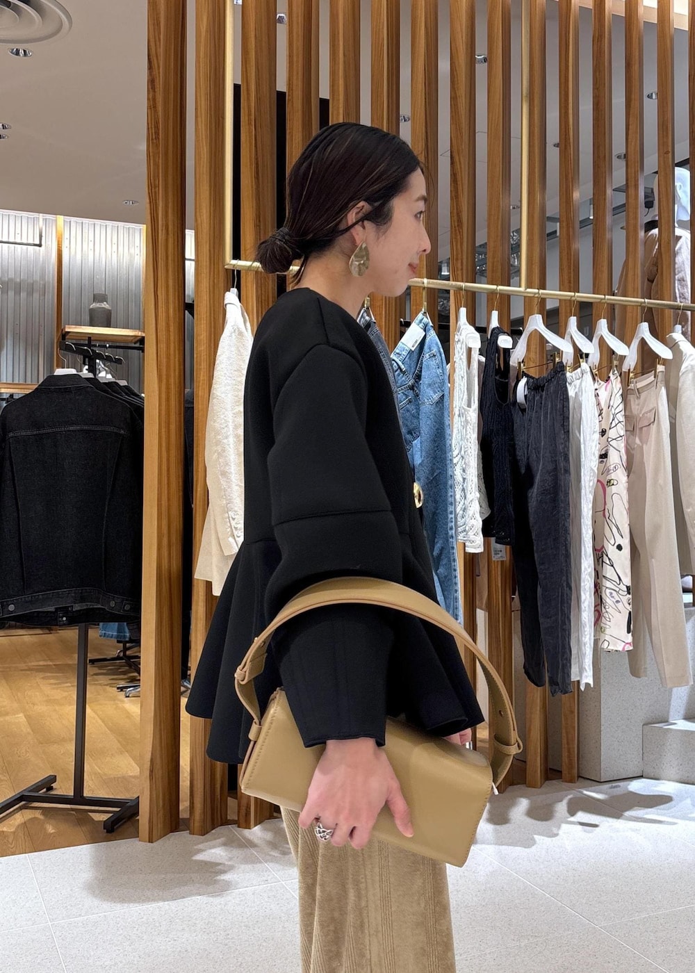 ベージュ系のハンドバッグ、ブラック系のローファー、ブラック系のカーディガン/ボレロを着用したレディースの冬コーディネートの8枚目の写真