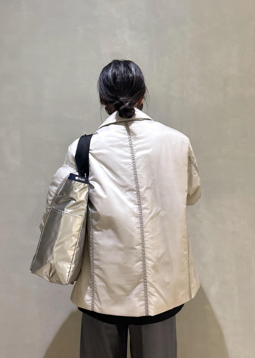 グレー系のスニーカー、ブラック系のシャツ/ブラウス、ベージュ系のブルゾンを着用したレディースの秋コーディネートの9枚目の写真